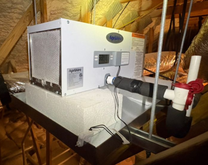 Aprilaire dehumidifer an attic, with ducting, controls, and condensate piping visible.