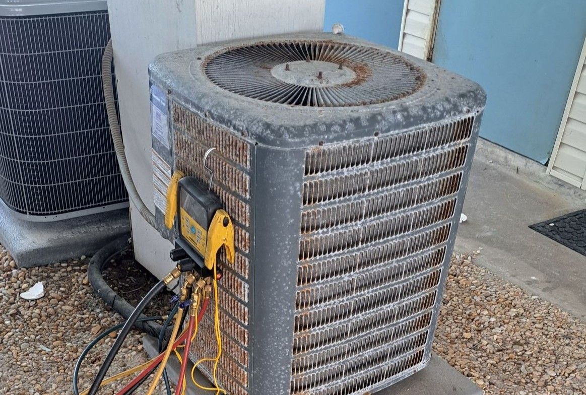 A broken and rusty air conditioner is mounted on the side of a building.