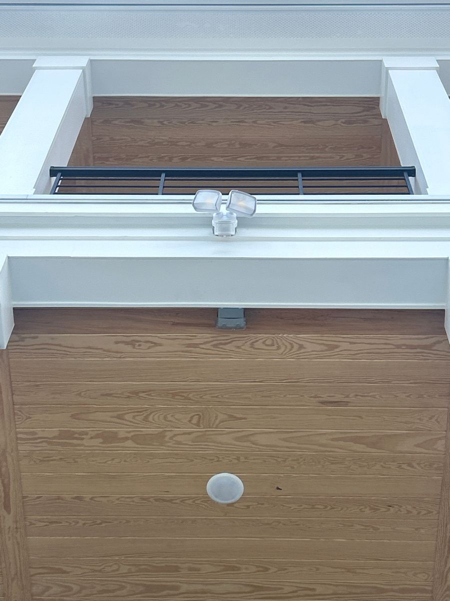 Interior view of a white-framed window above a wooden door with a round knob and metal railing