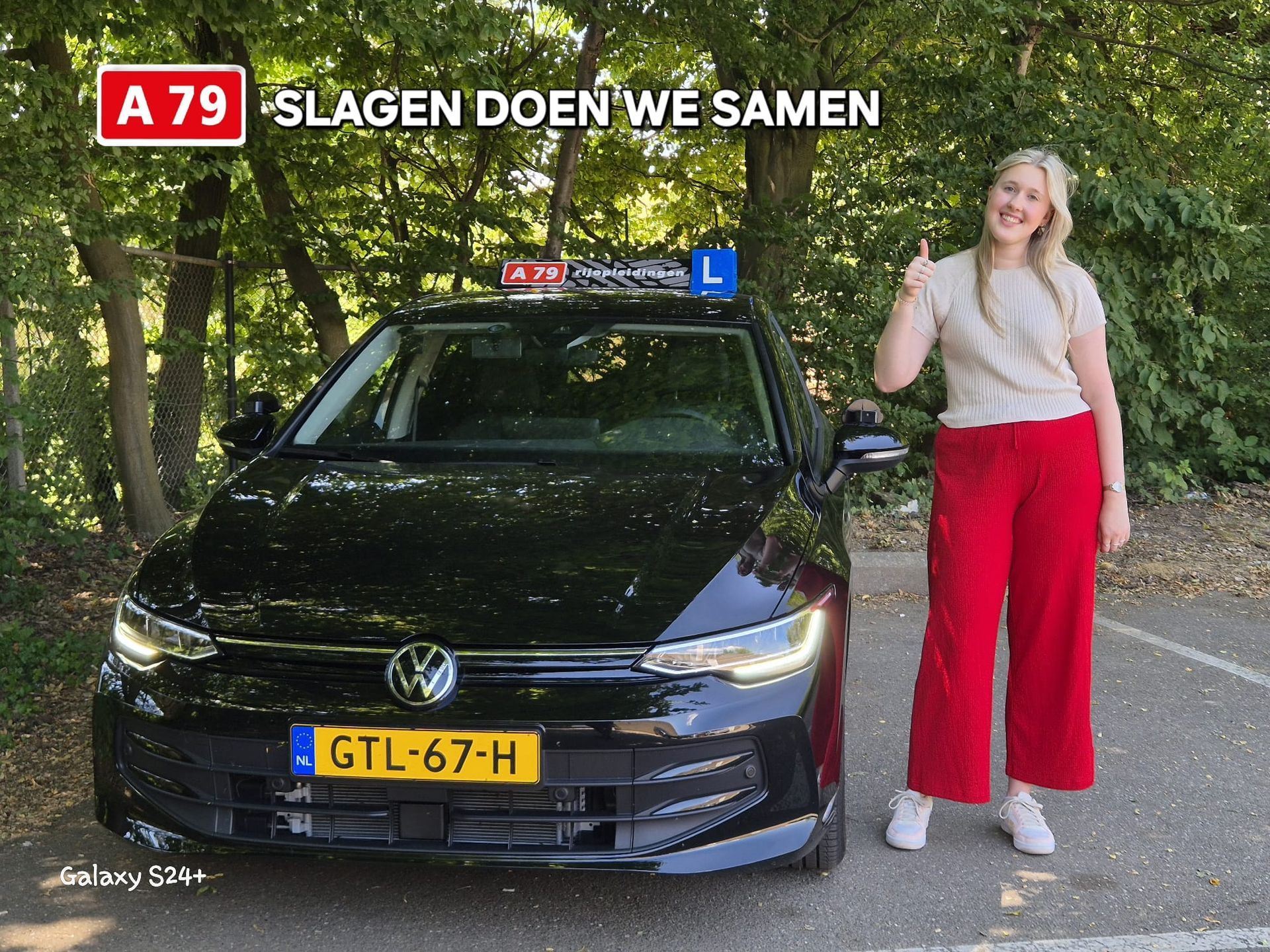 Vrouw met duim omhoog naast een zwarte auto met een 
