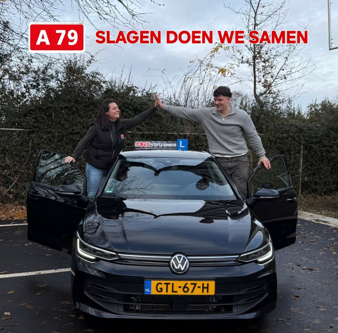 Iemand geeft een high-five aan een student naast een donkere Volkswagen met een 