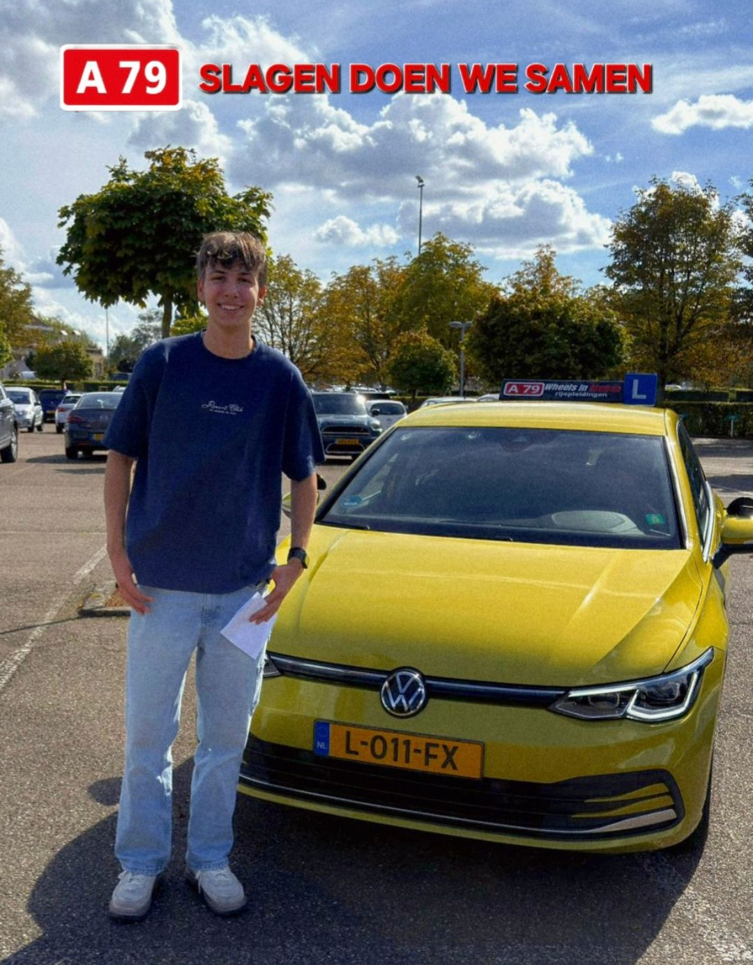 Een jonge man glimlacht naast een gele Volkswagen en houdt een papiertje vast. Buiten staat er: 