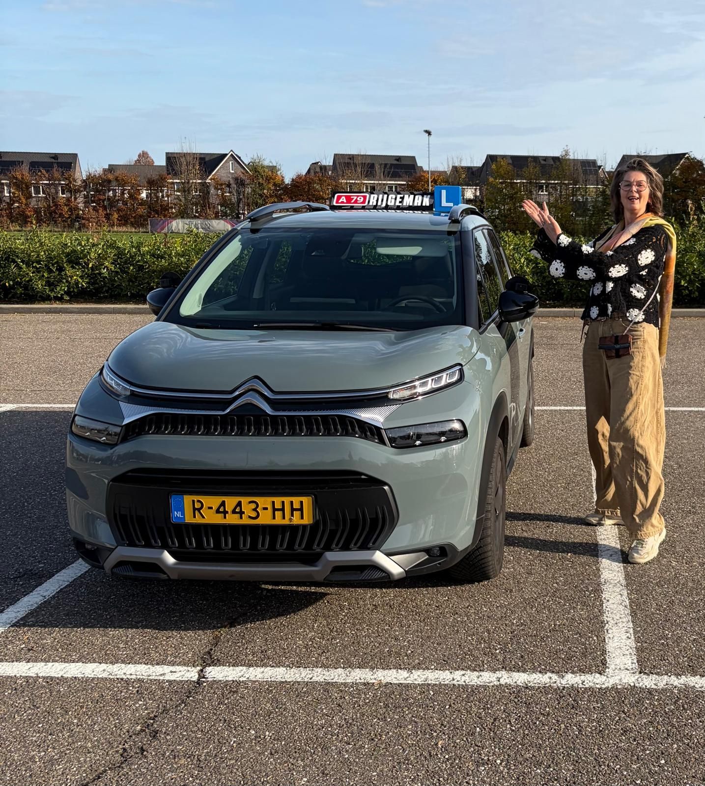 Vrouw naast een grijze Citroën met een 