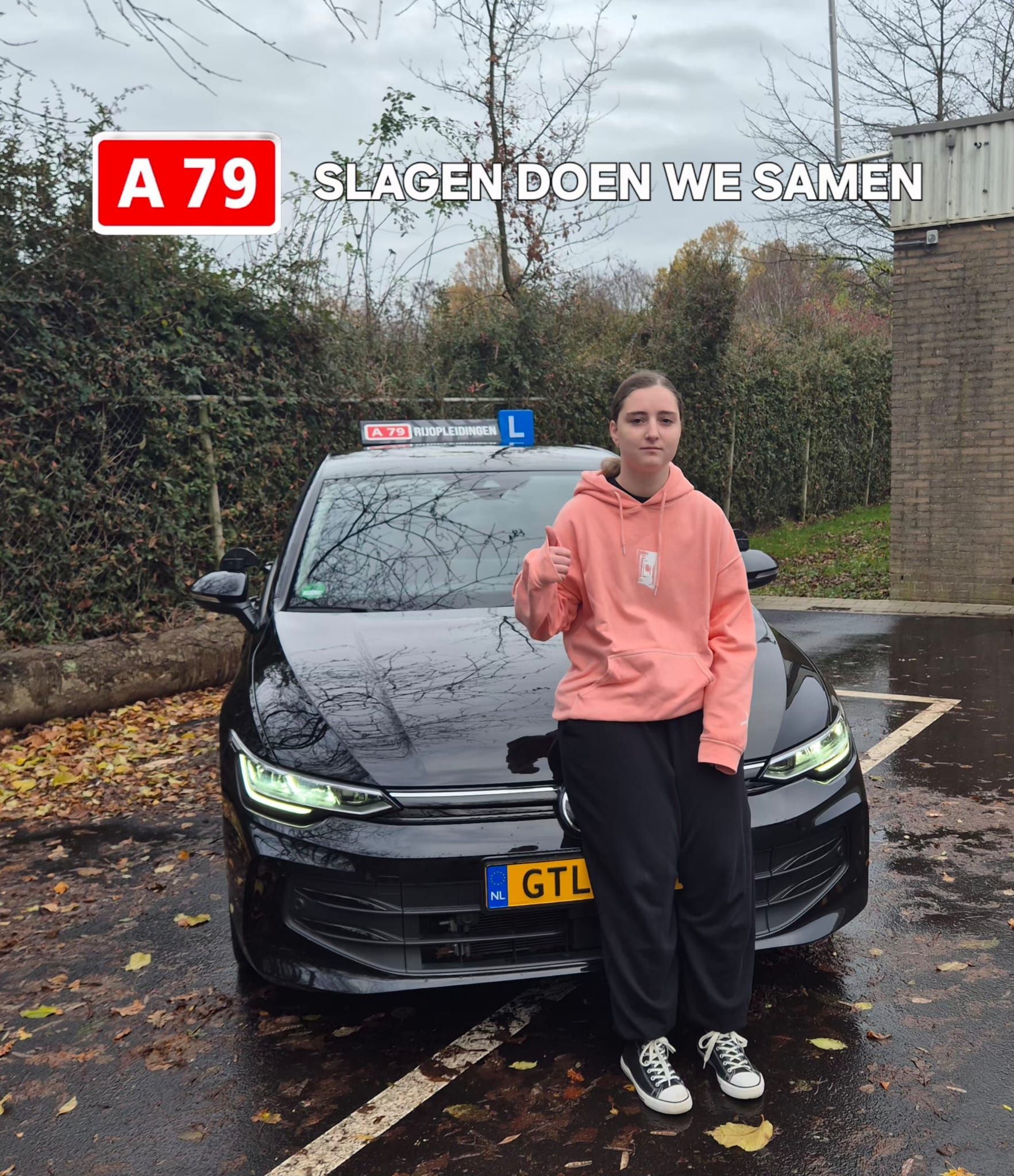 Een vrouw staat naast een zwarte auto met een 