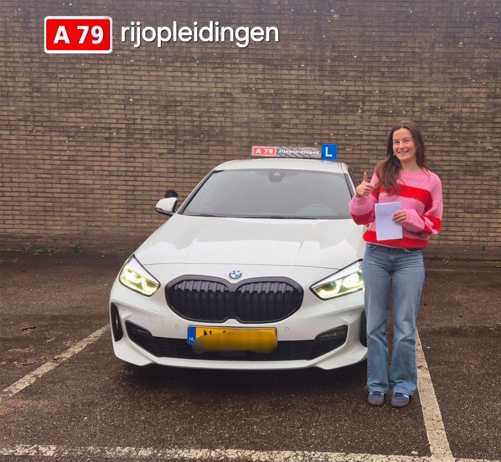 Vrouw met rijbewijs lacht naast een witte BMW, een lesauto van de rijschool.