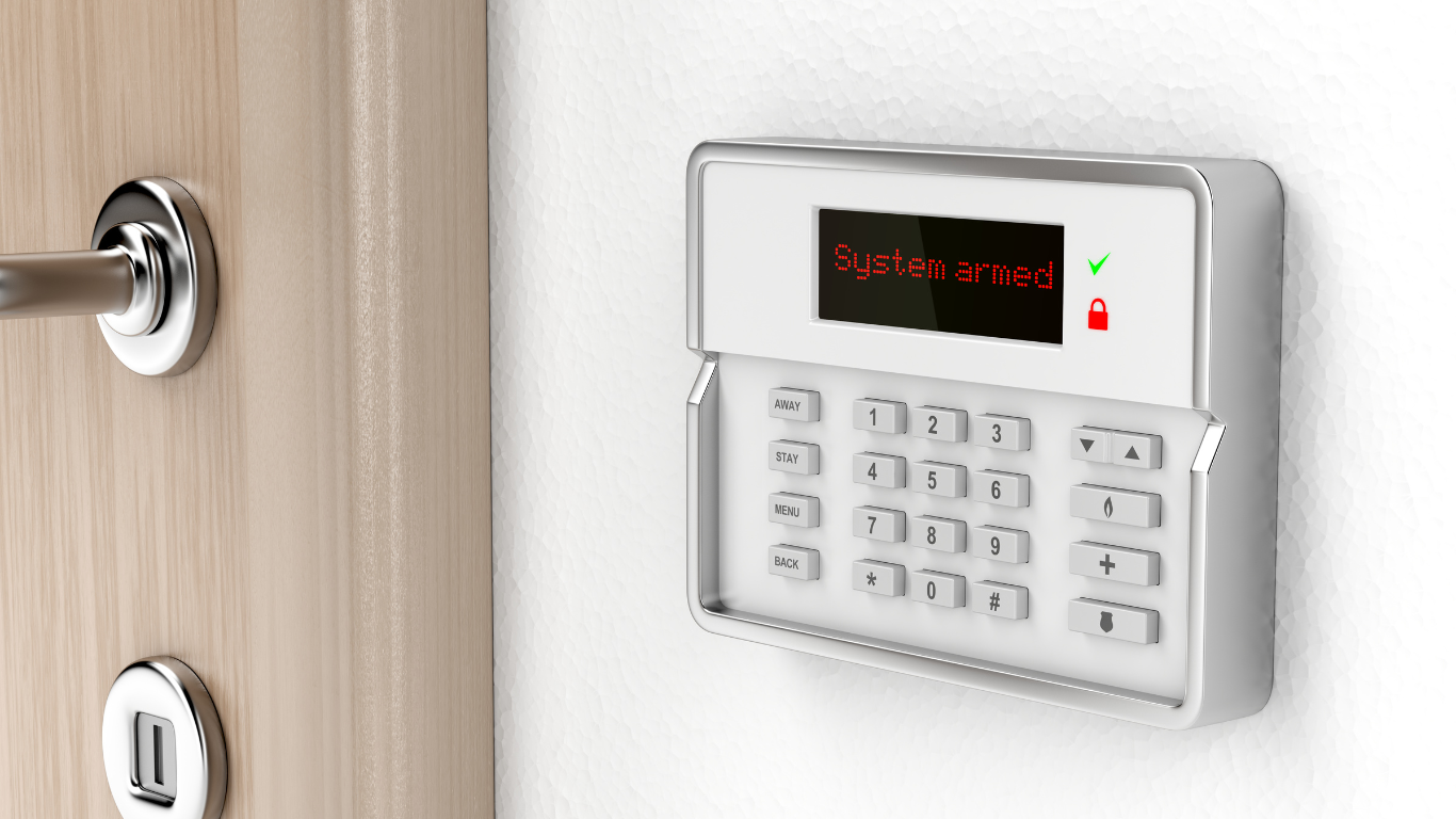 A person is holding a cell phone in front of a security system.