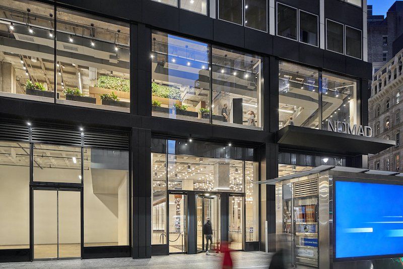 A large building with a lot of windows and a billboard in front of it.