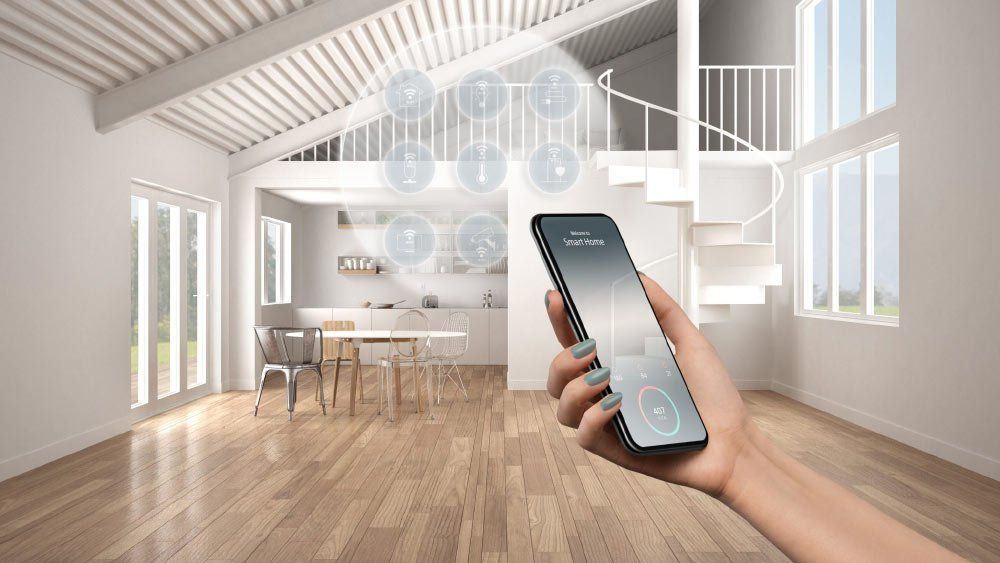 A person is holding a smart phone in a living room.