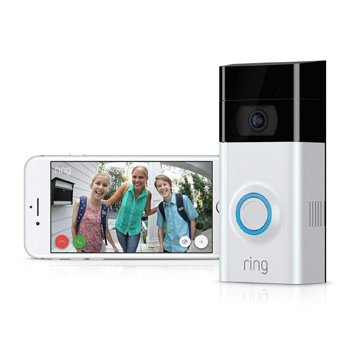 A ring doorbell is sitting next to a cell phone.
