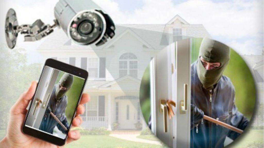 A person is holding a cell phone with a picture of a burglar on it.