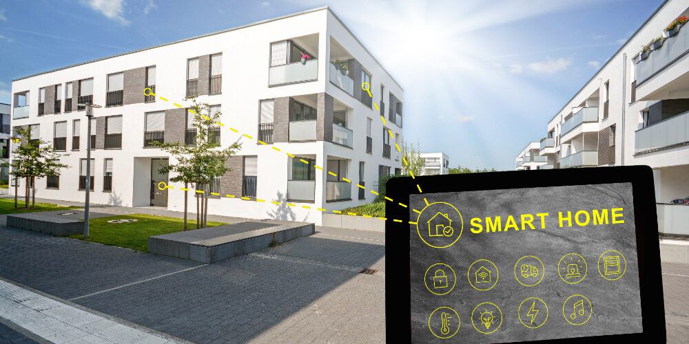 A smart home is being displayed on a tablet in front of a building.