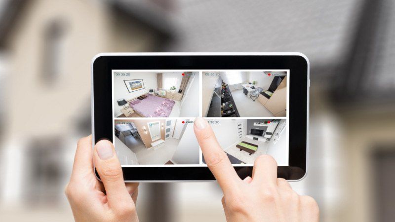 A person is holding a tablet with a picture of a house on it.