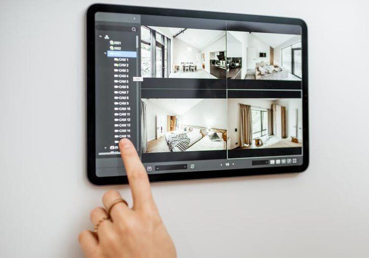A person is pointing at a tablet with a picture of a house on it.