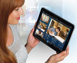 A woman is holding a tablet with a picture of a man on it.