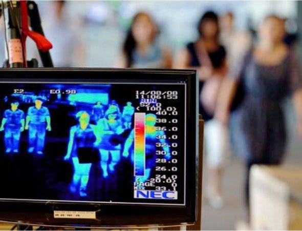 A group of people are walking in front of a nec monitor