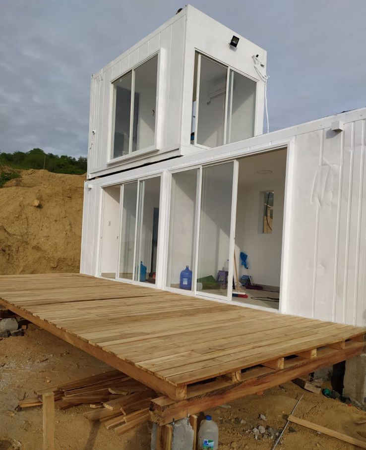 Una casa modular blanca de dos plantas en construcción, con grandes puertas correderas