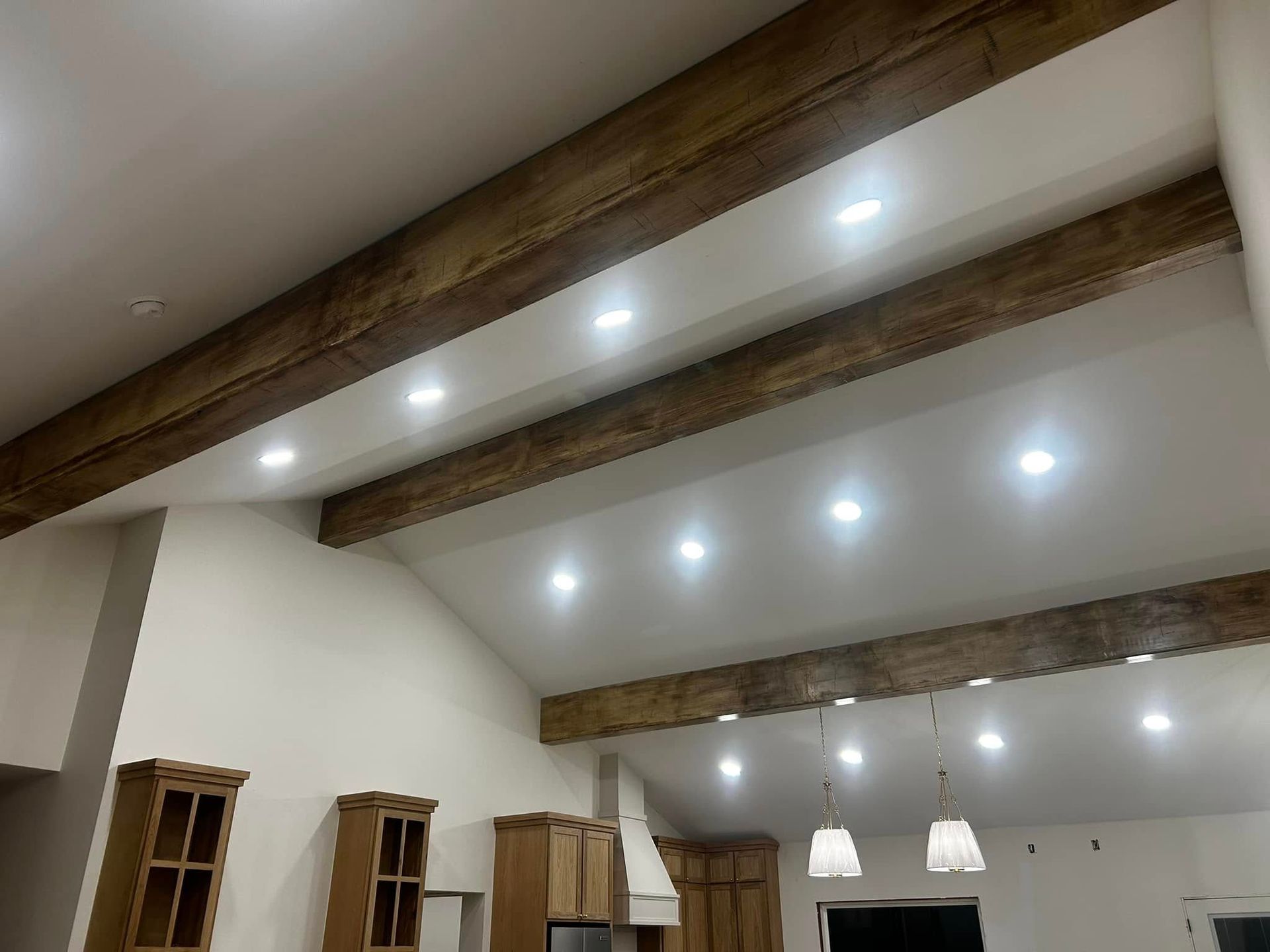 Modern room interior with exposed wood beams and recessed ceiling lights