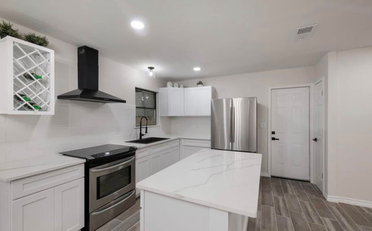 Bright modern white kitchen with stainless steel appliances and a central island