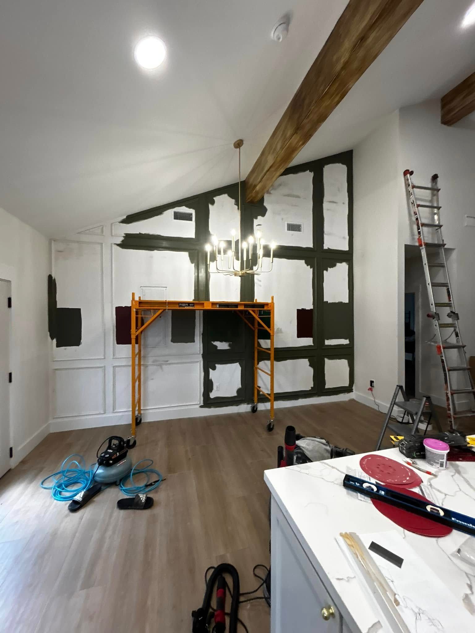 Renovation scene with white walls, exposed wood beam, ladder, scaffolding, and tools on the floor