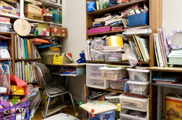 Room in a hoarded house in Cardiff with shelves overflowing with books, magazines and other items, ready for clearance by J&Z House Clearance