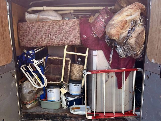 Back of a van loaded with furniture, an appliance, paint tins and household items from the Penarth garage