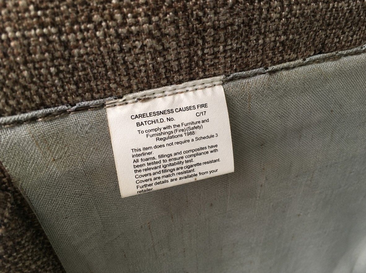 Fire safety label on a sofa cushion, relevant to reuse and donation rules in the UK