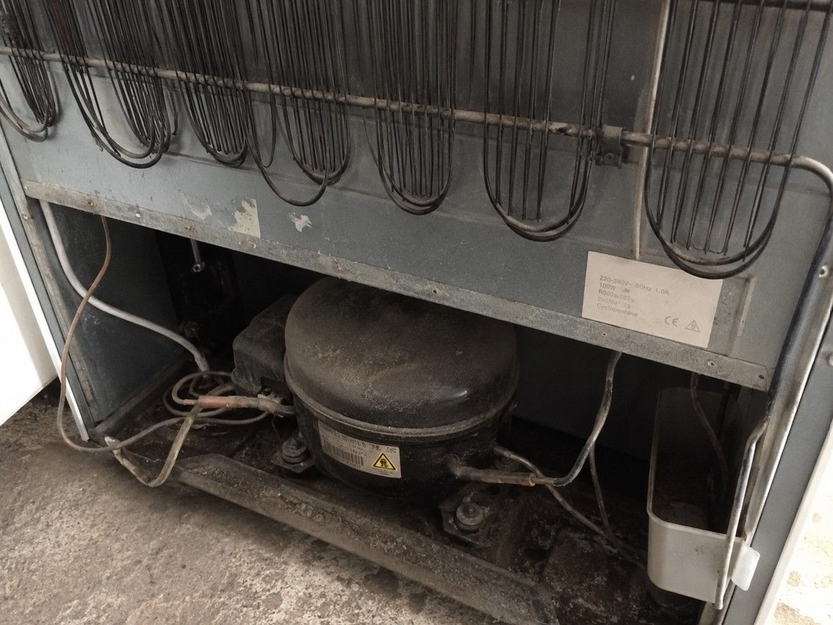Rear compressor unit of an old fridge awaiting WEEE-compliant disposal in Cardiff
