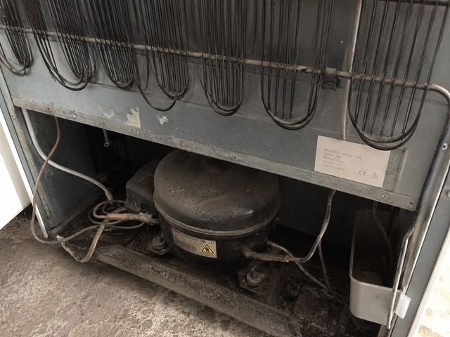 Rear compressor unit of an old fridge awaiting WEEE-compliant disposal in Cardiff