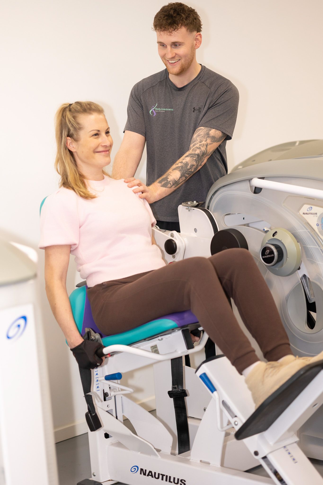 Tim begeleidt een lid op de leg press