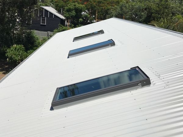 White corrugated metal roof with three rectangular skylights.