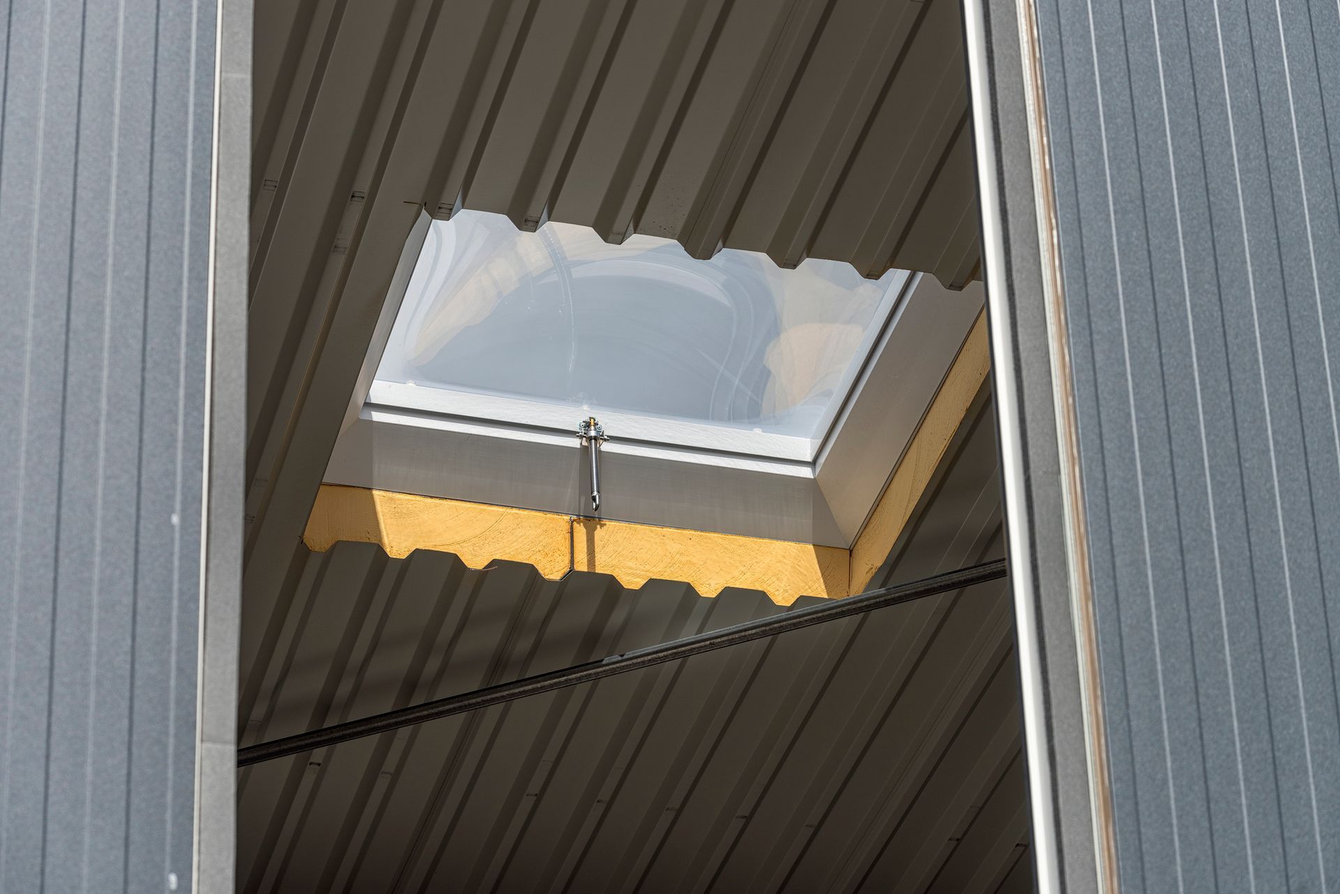 A low-angle view shows a skylight mounted on the roof of a building.