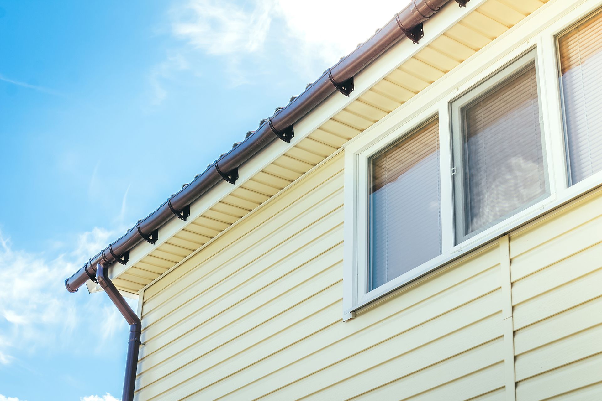 A house with a gutter on the side of it and a window.