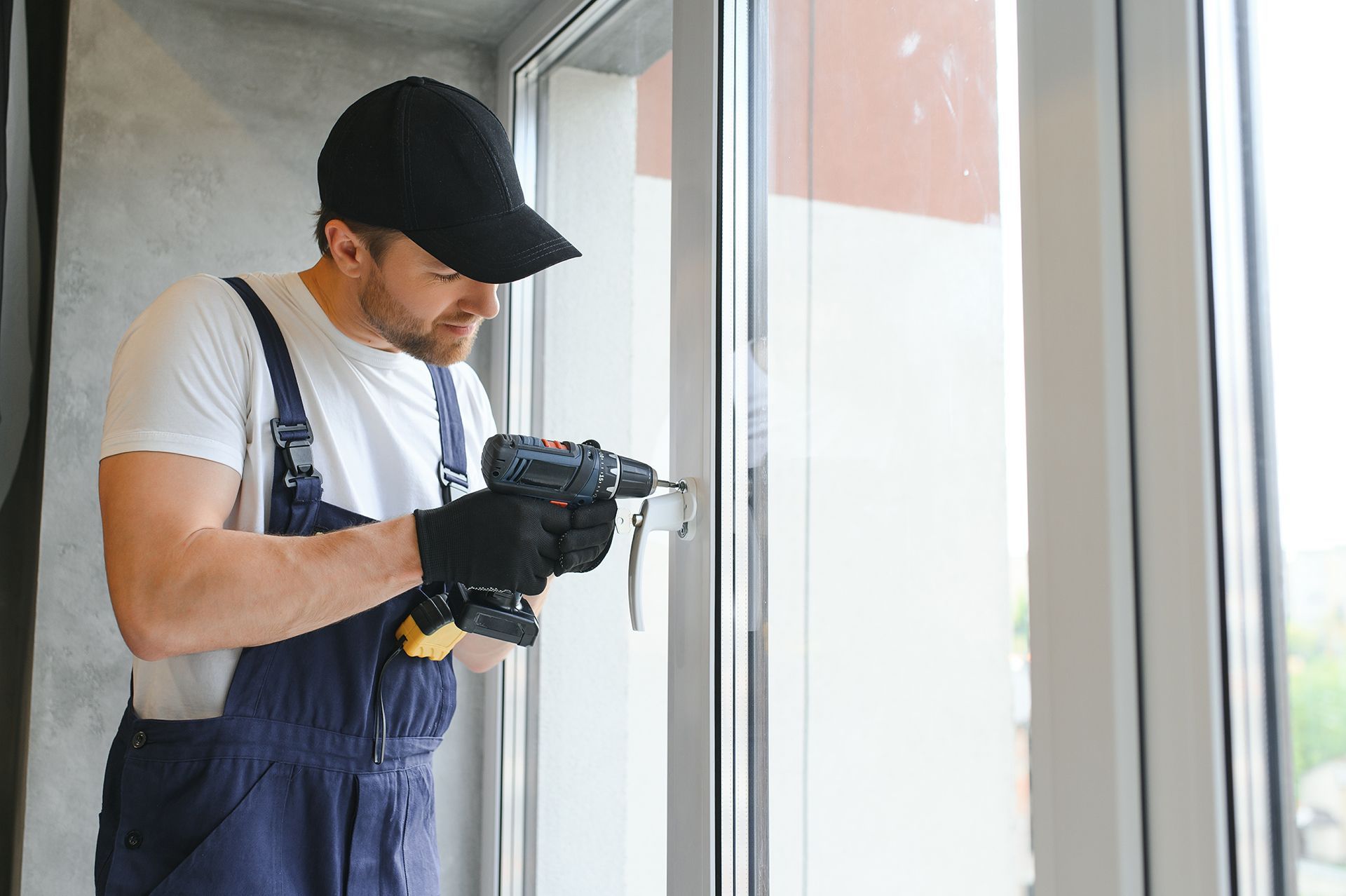 A man is installing a window with a drill.