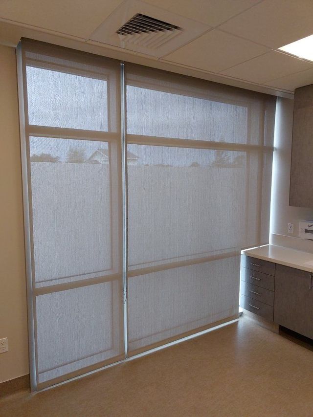 A room with a lot of windows and blinds on them.