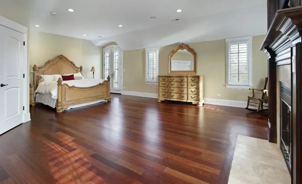 A large bedroom with hardwood floors and a fireplace