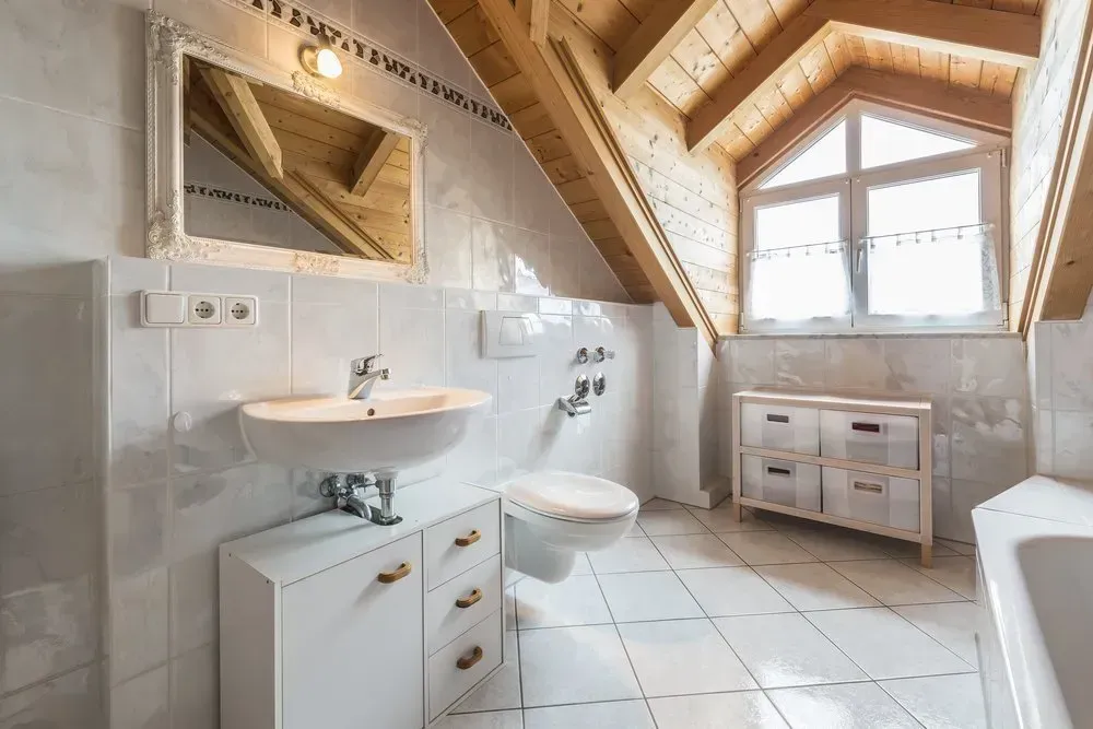 A bathroom with a toilet, sink, mirror and window