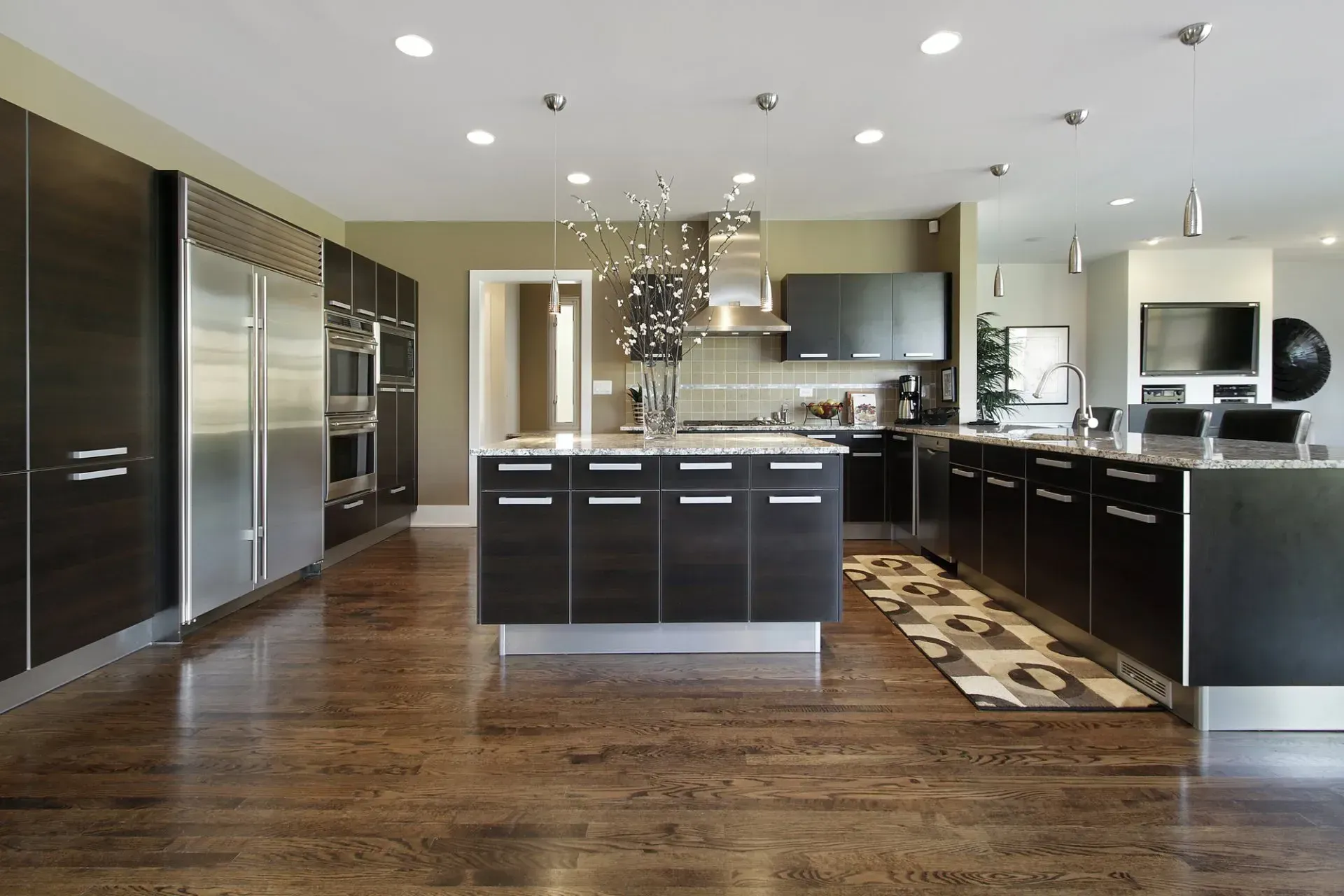 A kitchen with black cabinets and stainless steel appliances