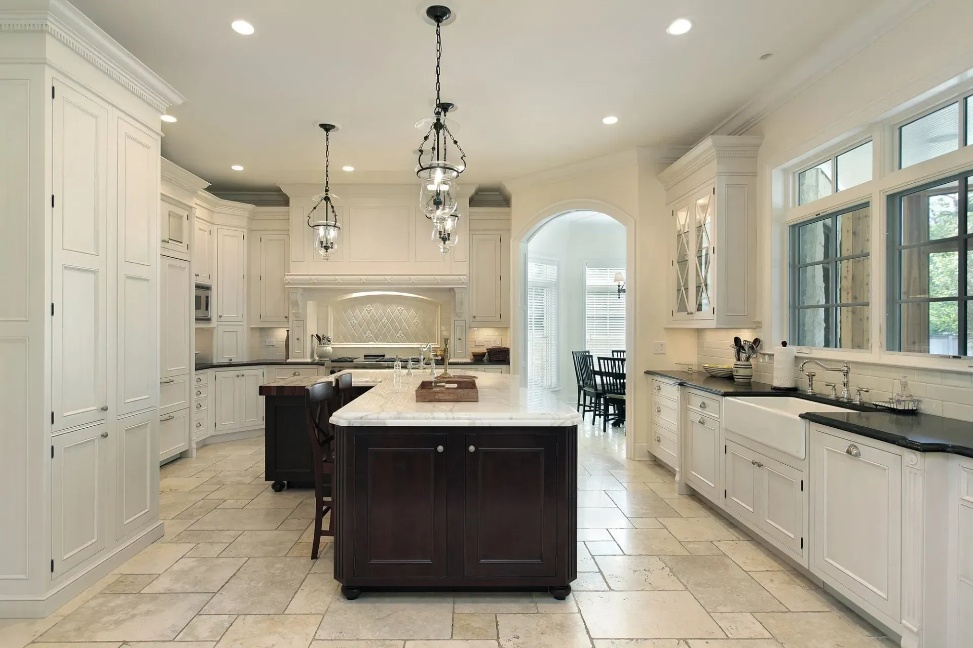 A kitchen with white cabinets and a large island