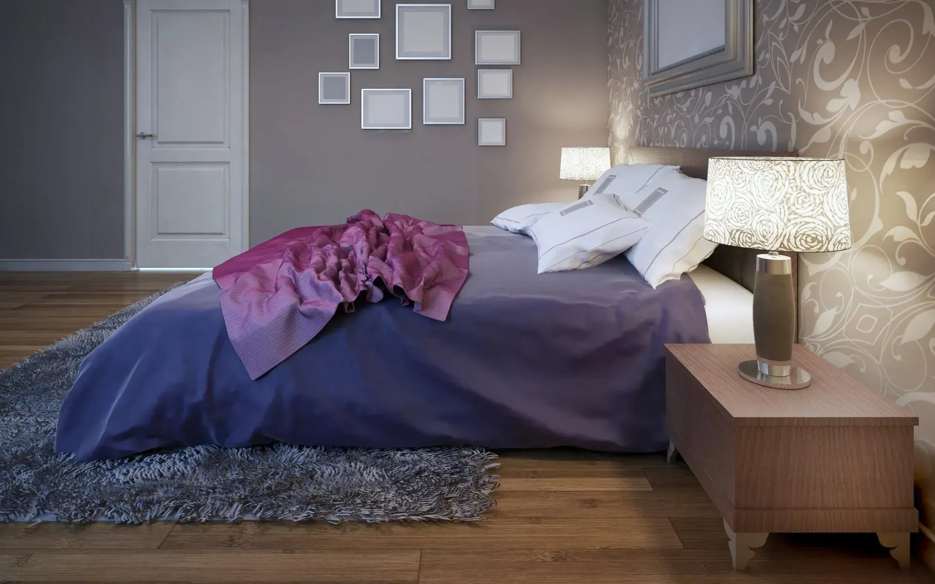 A bedroom with a bed, nightstand, lamp, and pictures on the wall