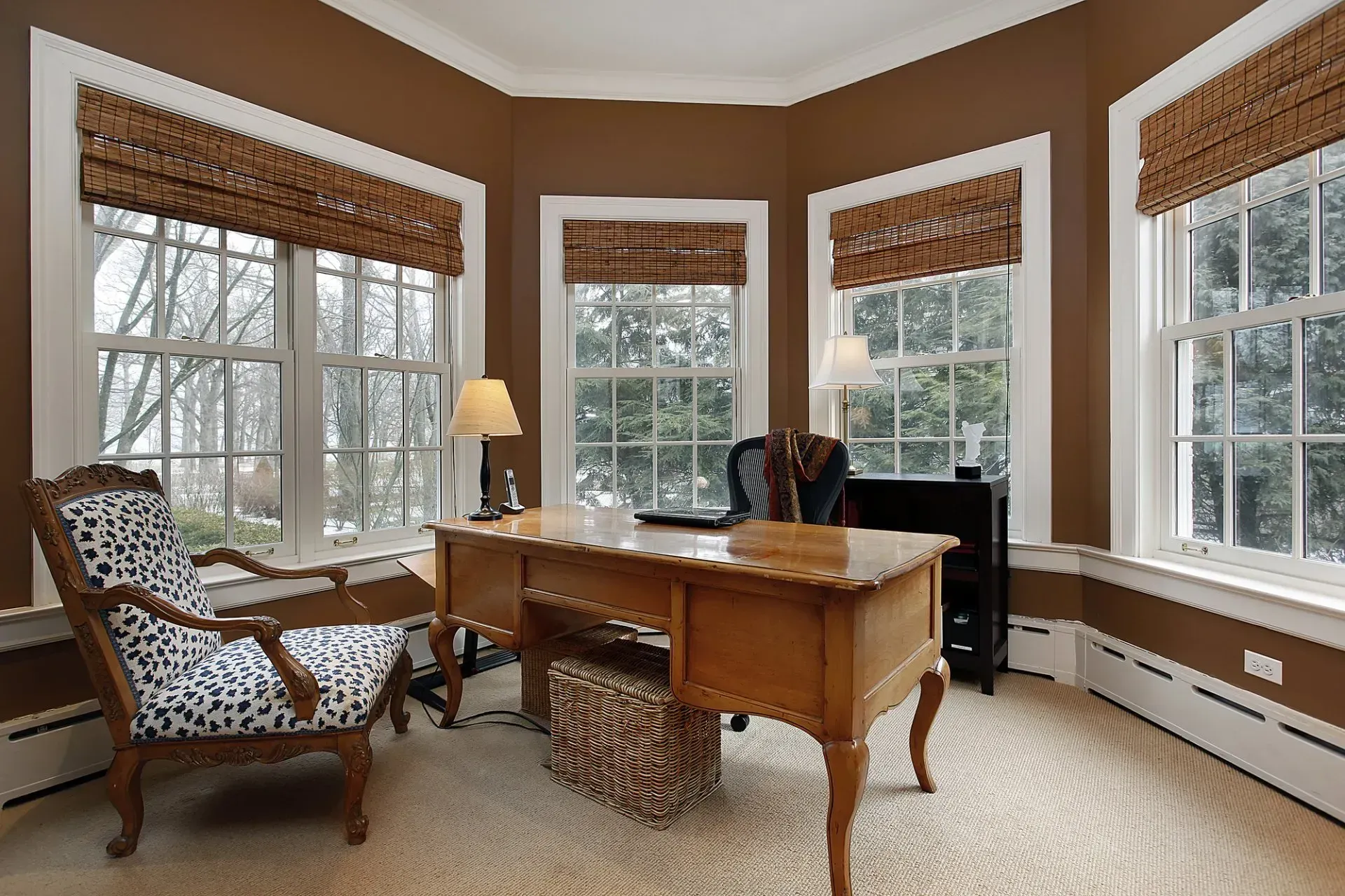 A home office with a desk and chairs and lots of windows