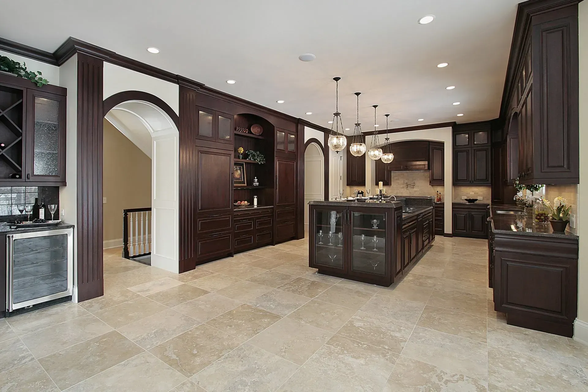 A large kitchen with dark wood cabinets and a large island