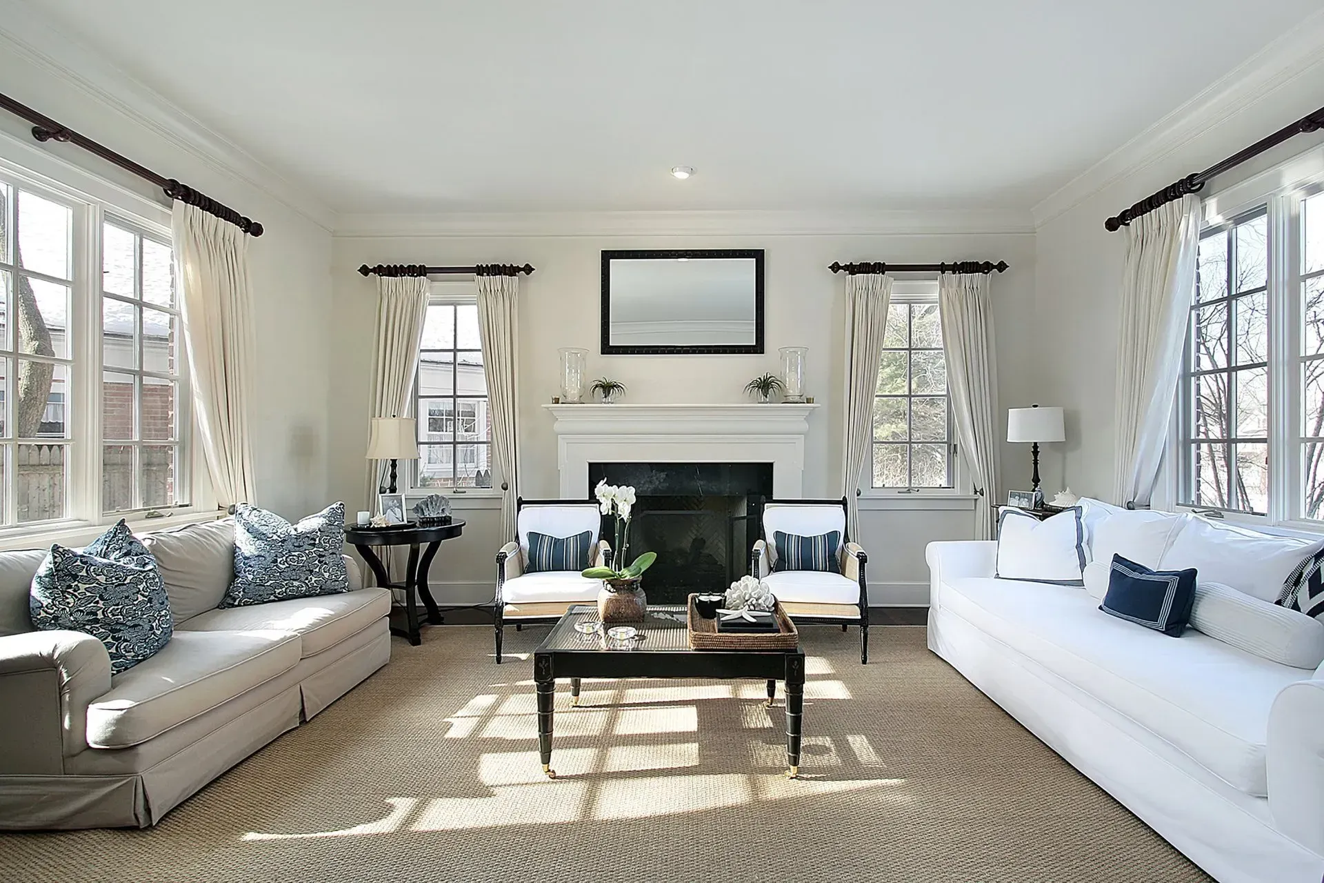A living room with white furniture and a fireplace