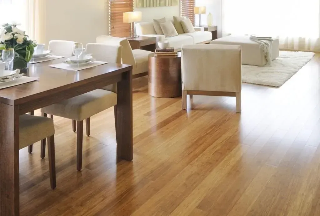 A living room with a wooden floor and a table and chairs