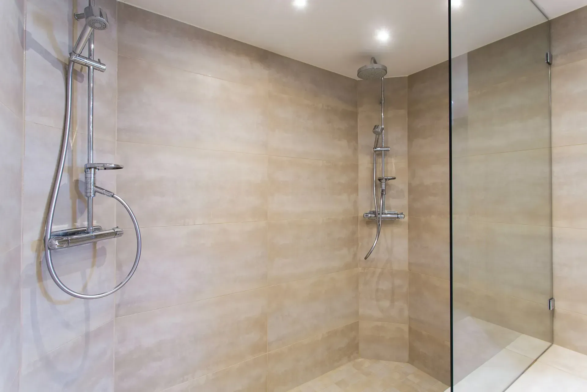 A bathroom with a walk in shower and a shower head