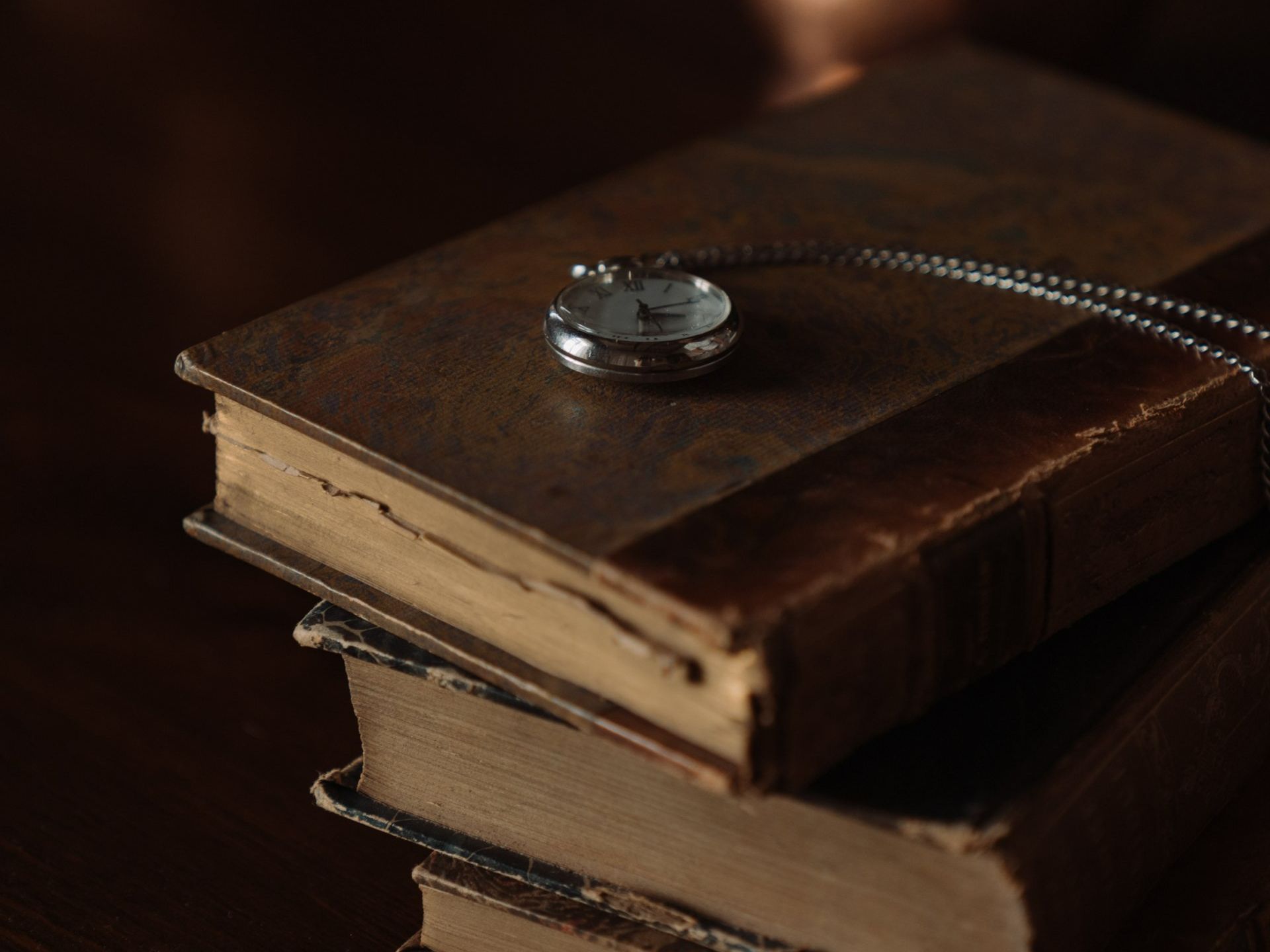 Pocket watch over a pile of books