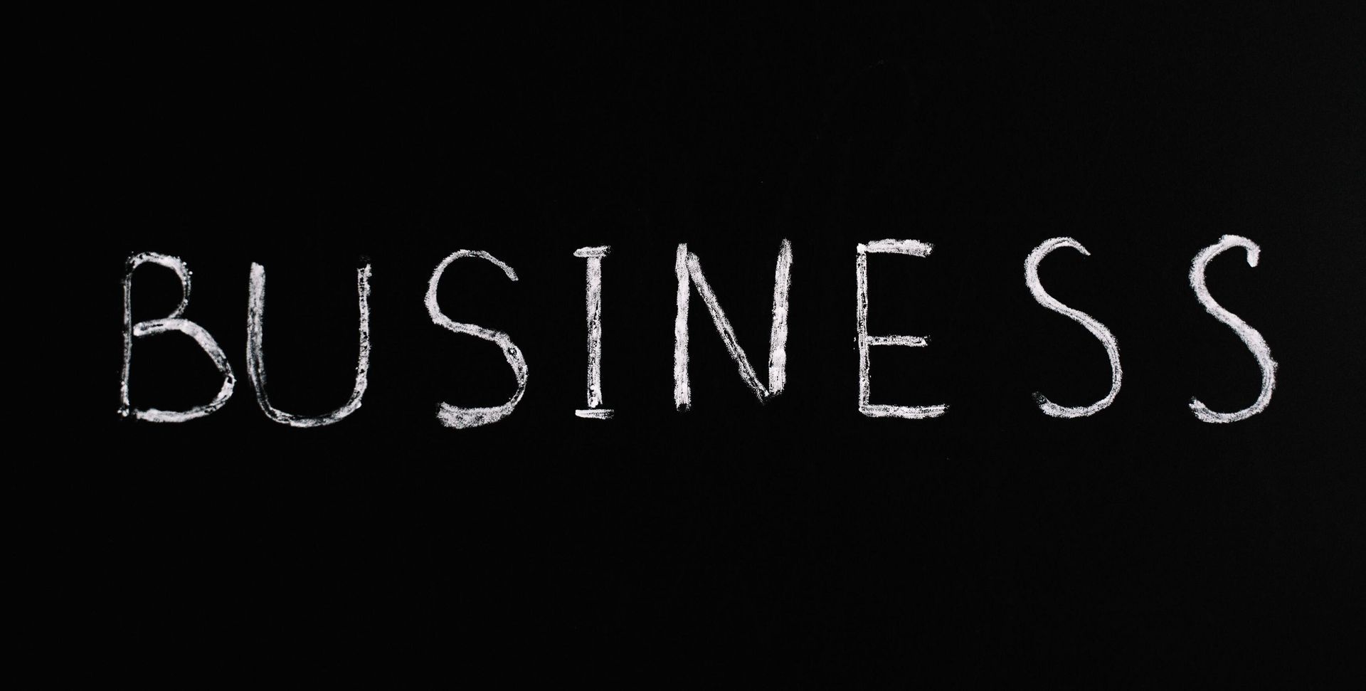 White chalk-style word “BUSINESS” on a black background.