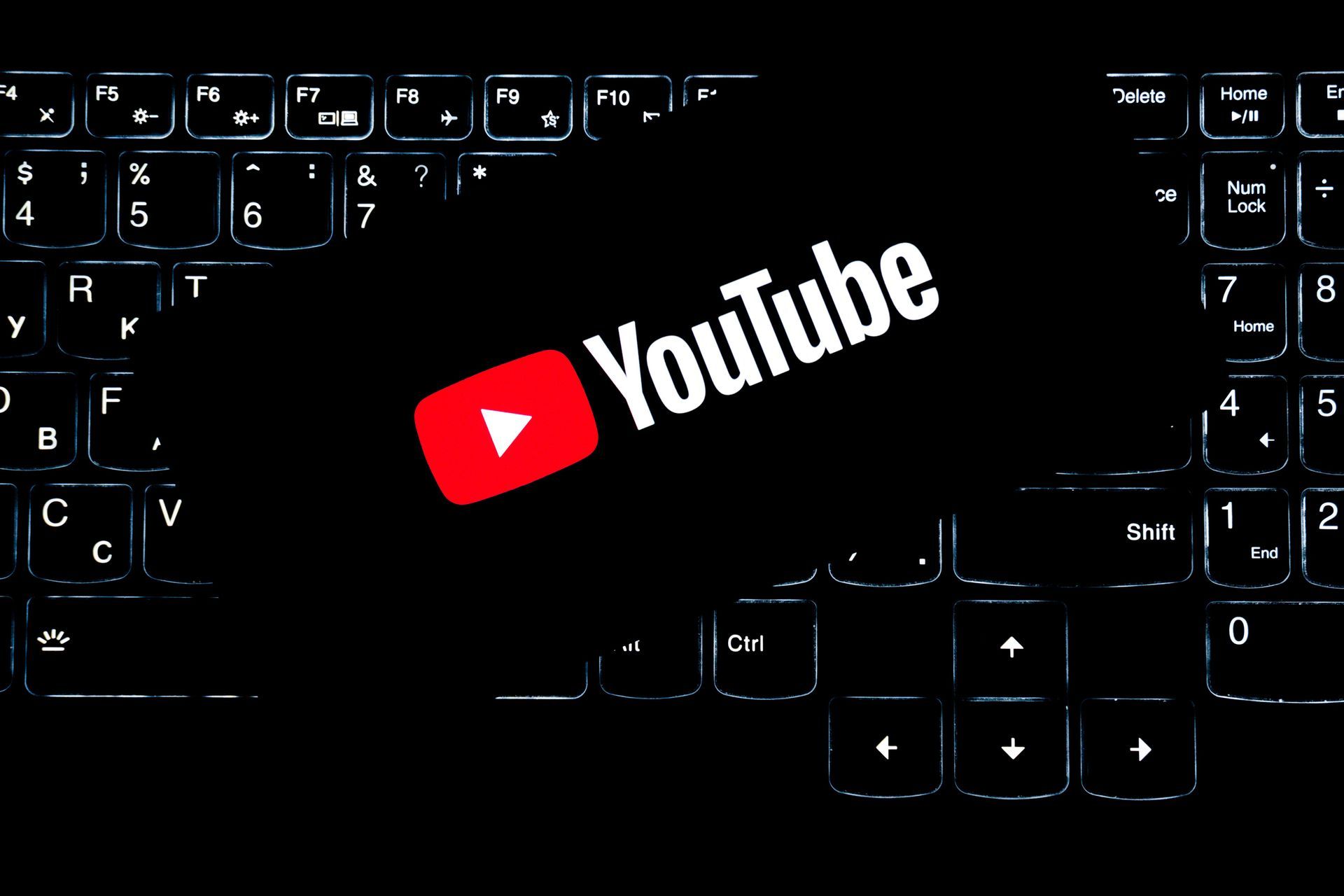 YouTube logo on a dark keyboard background
