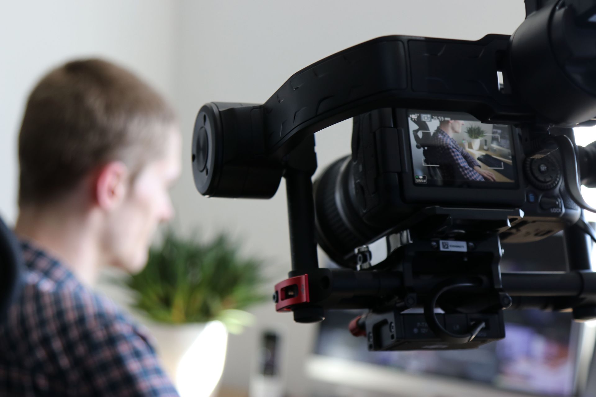 Video camera filming a blurred person in an indoor studio setting