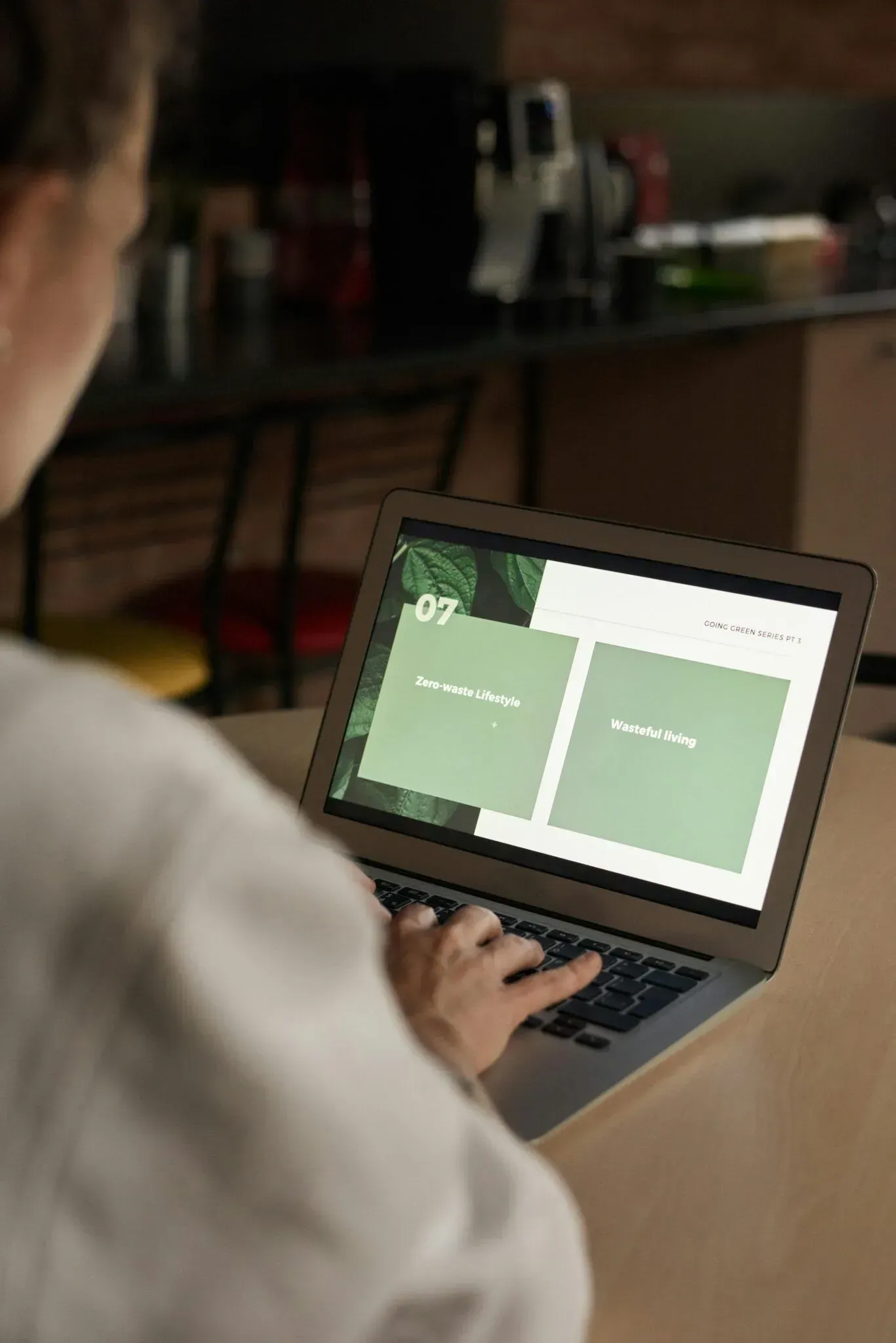 Person using a laptop with a green split-screen display in a dim indoor setting