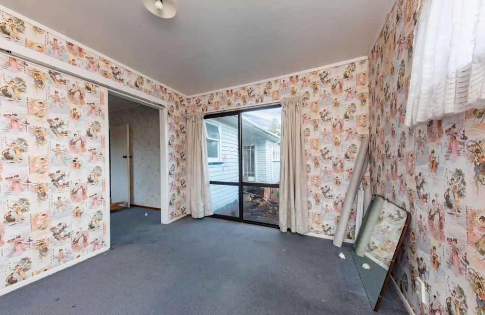Empty room with floral wallpaper, gray carpet, and sliding glass door to a deck